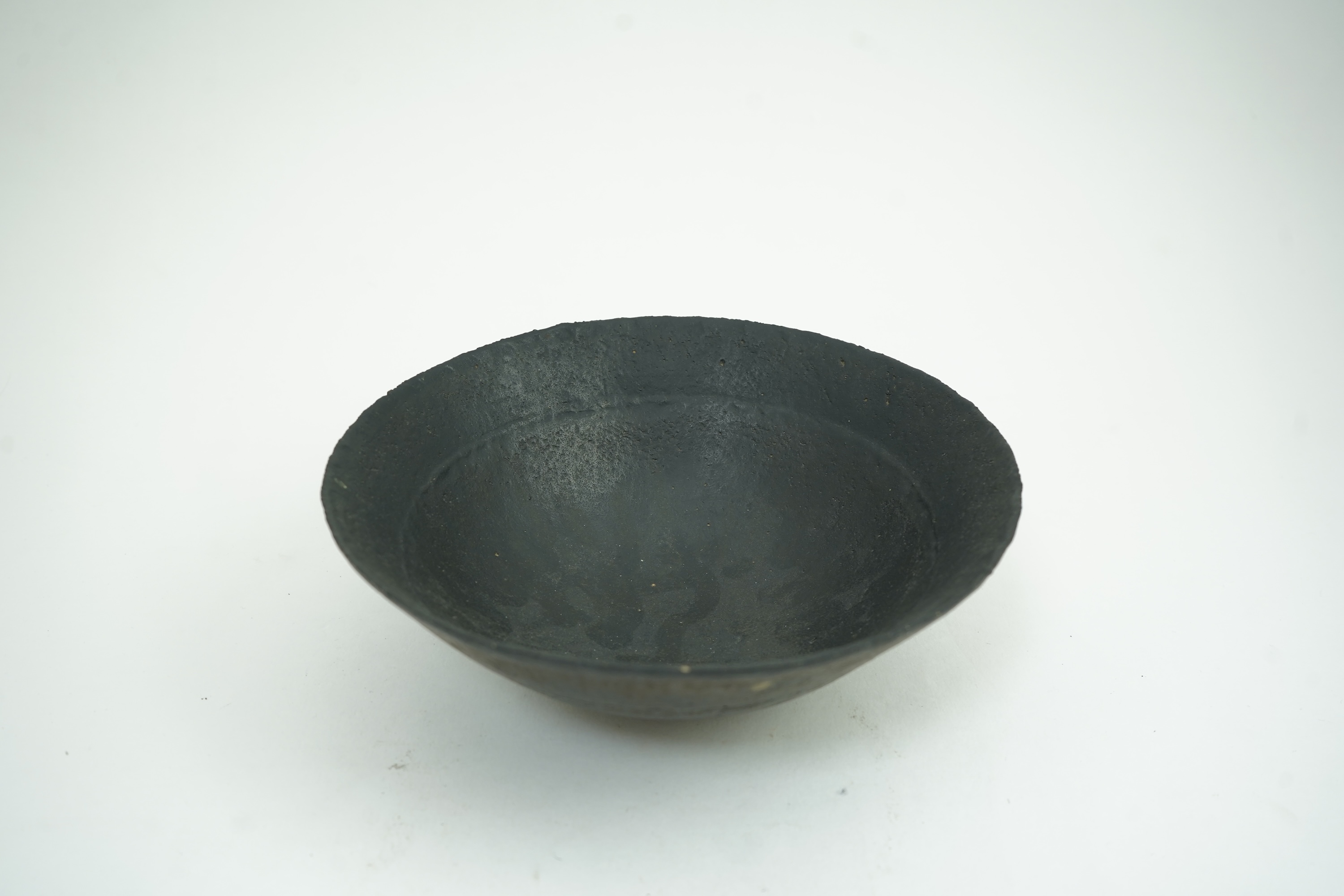 John Ward (1938-2023): A hand-built stoneware black glazed bowl with irregular rim
